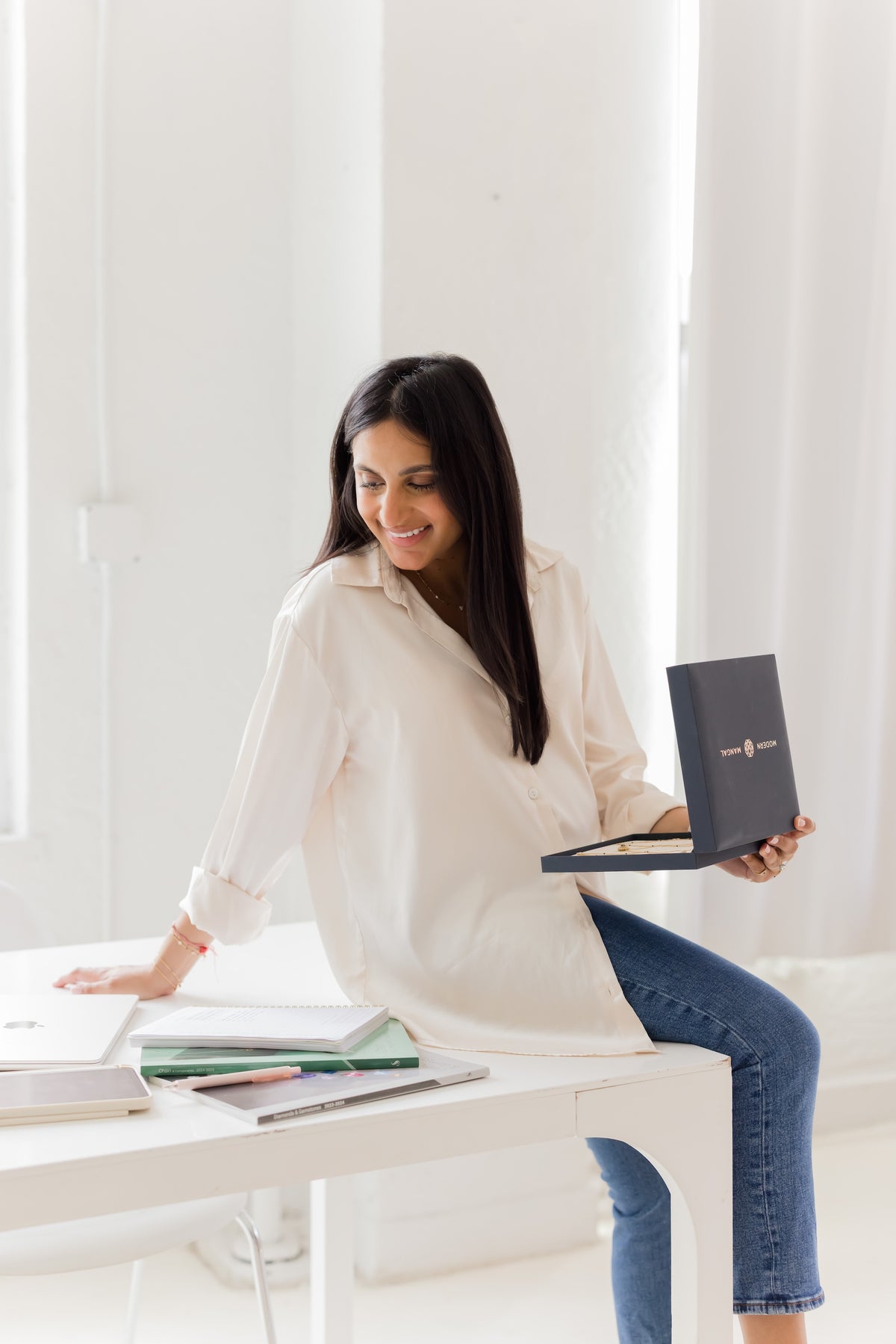 Shreya Sanghvi Rastogi, founder of Modern Mangal, at her desk with a tray of pieces
