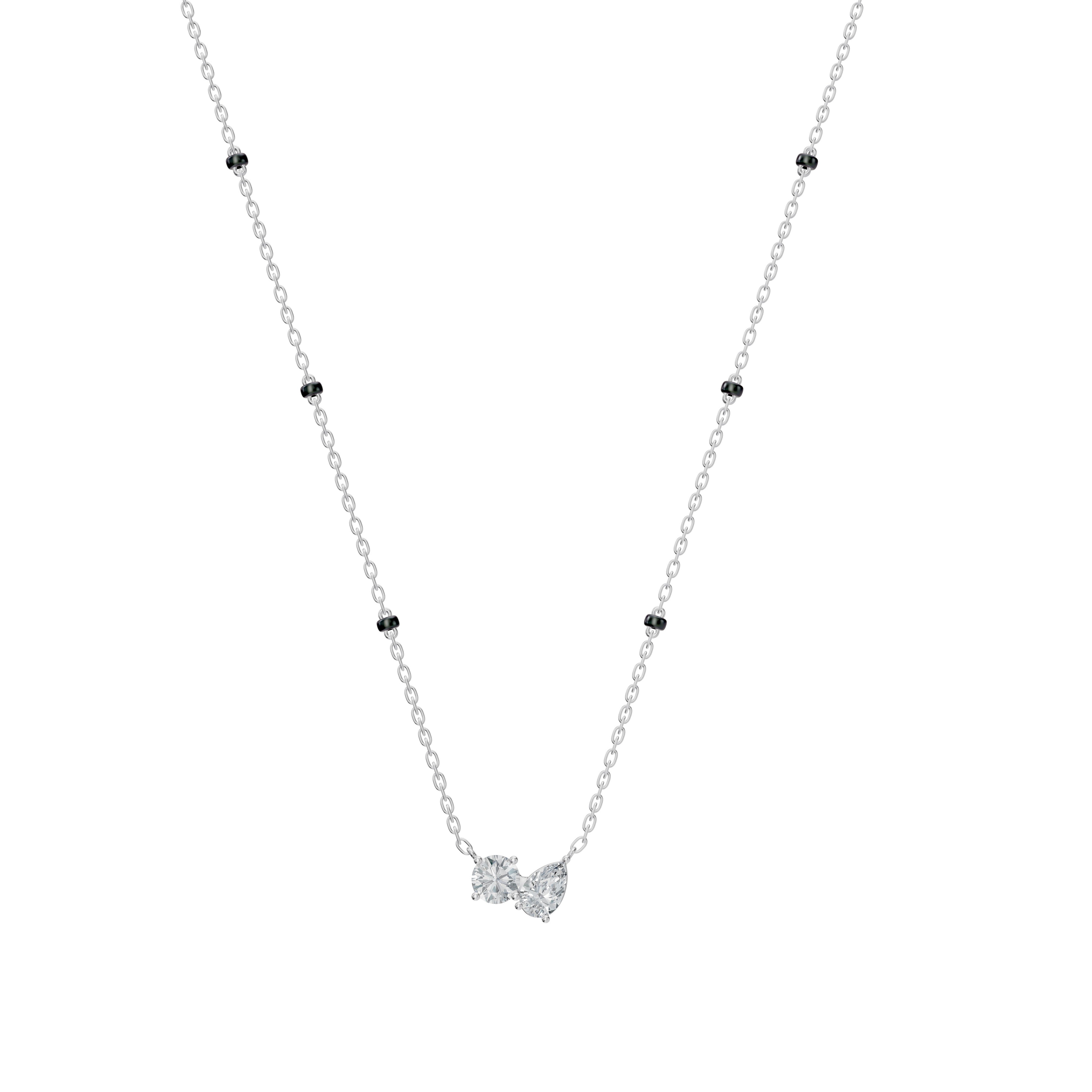 Front-facing image of the modern manga lAmari Mangalsutra in white gold, featuring an elegant Toi et Moi pendant with pear and round diamonds and a modern dual-bead chain. 