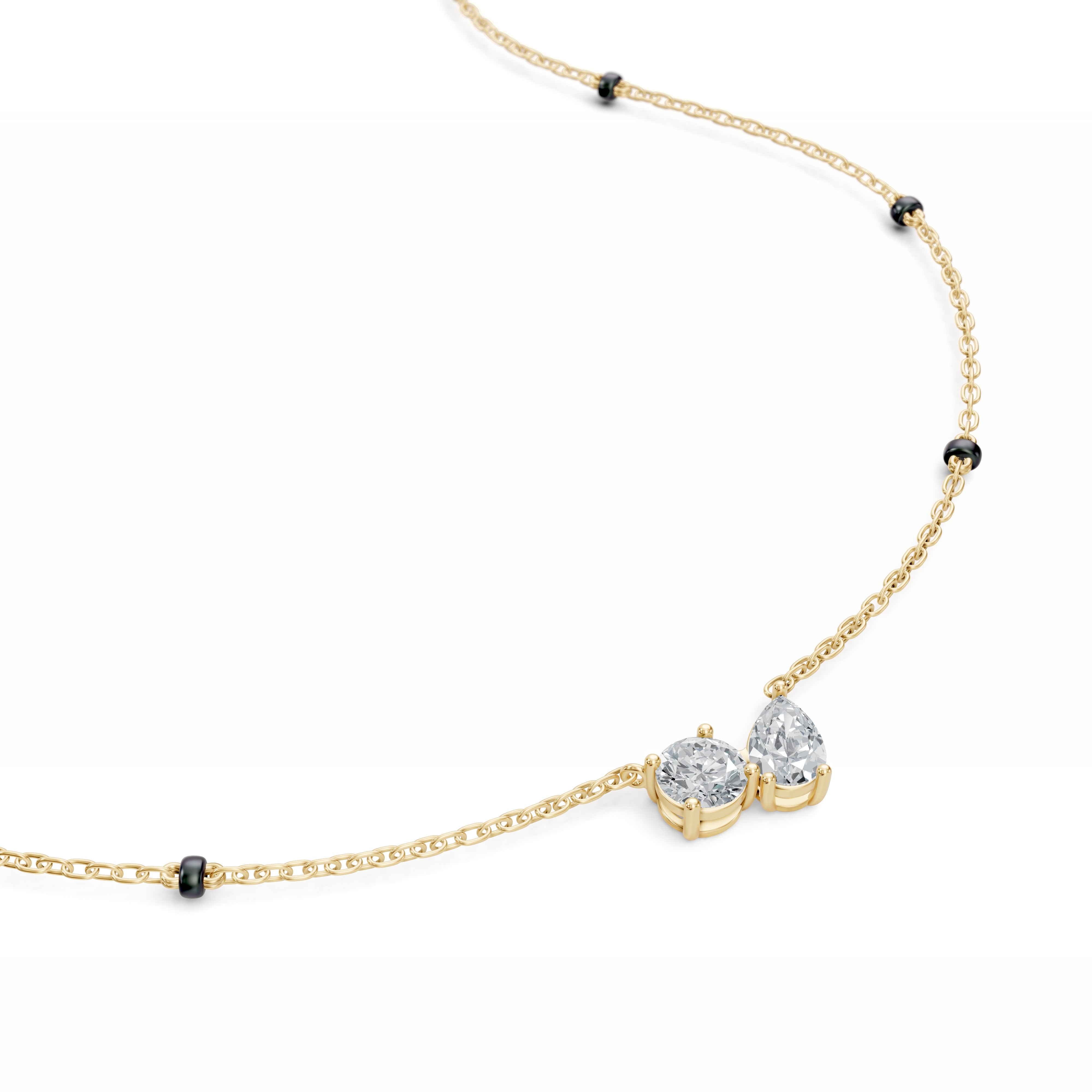 Close-up of the Modern Mangal Amari pendant in yellow gold, highlighting the asymmetric pairing of pear and round diamonds in a romantic Toi et Moi setting.