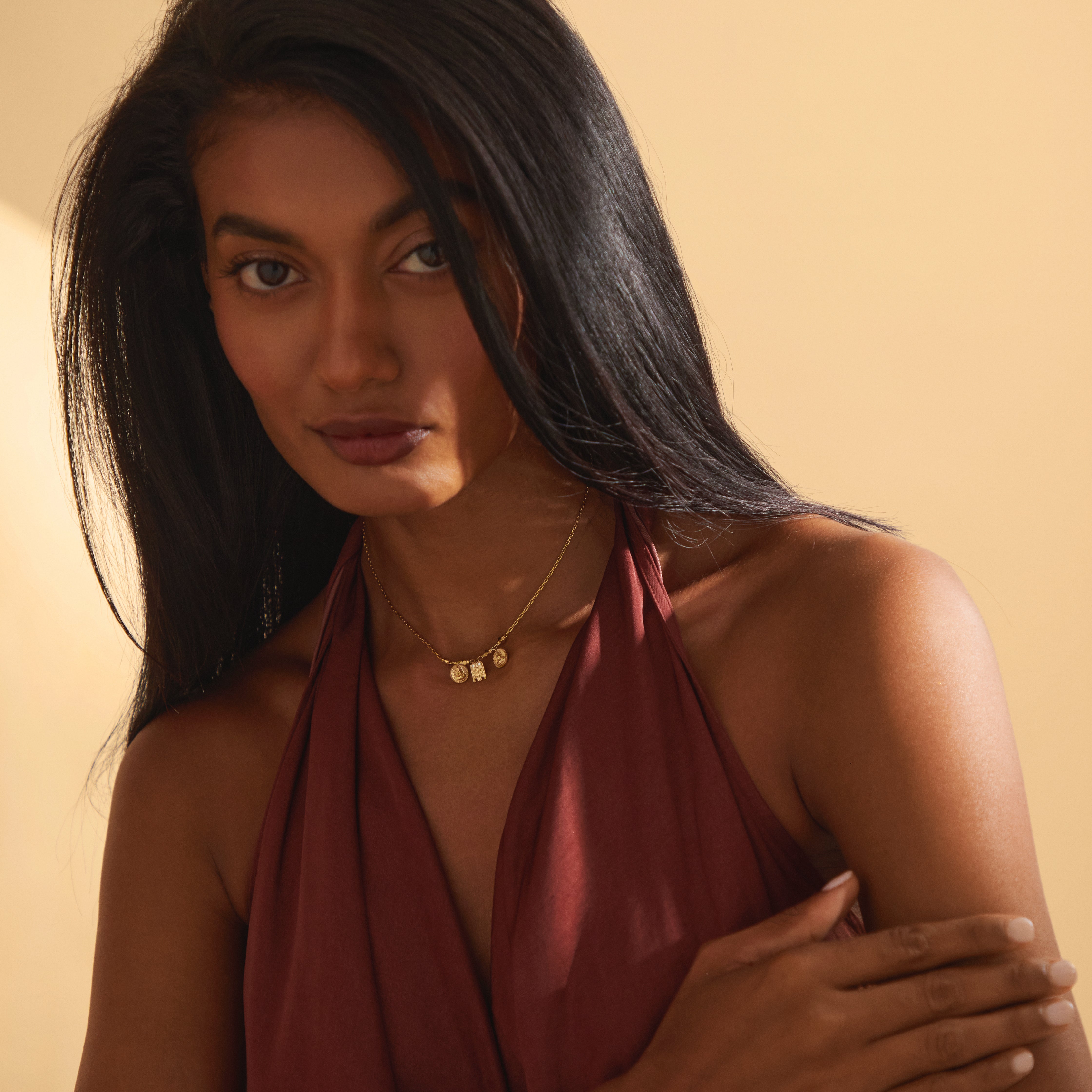 A close-up of the Sriya Mangalayam pendant in yellow gold, featuring a central Tamil mangalayam flanked by two Lakshmi kasu coins and four angular gold beads, designed by Modern Mangal to symbolize prosperity and heritage.