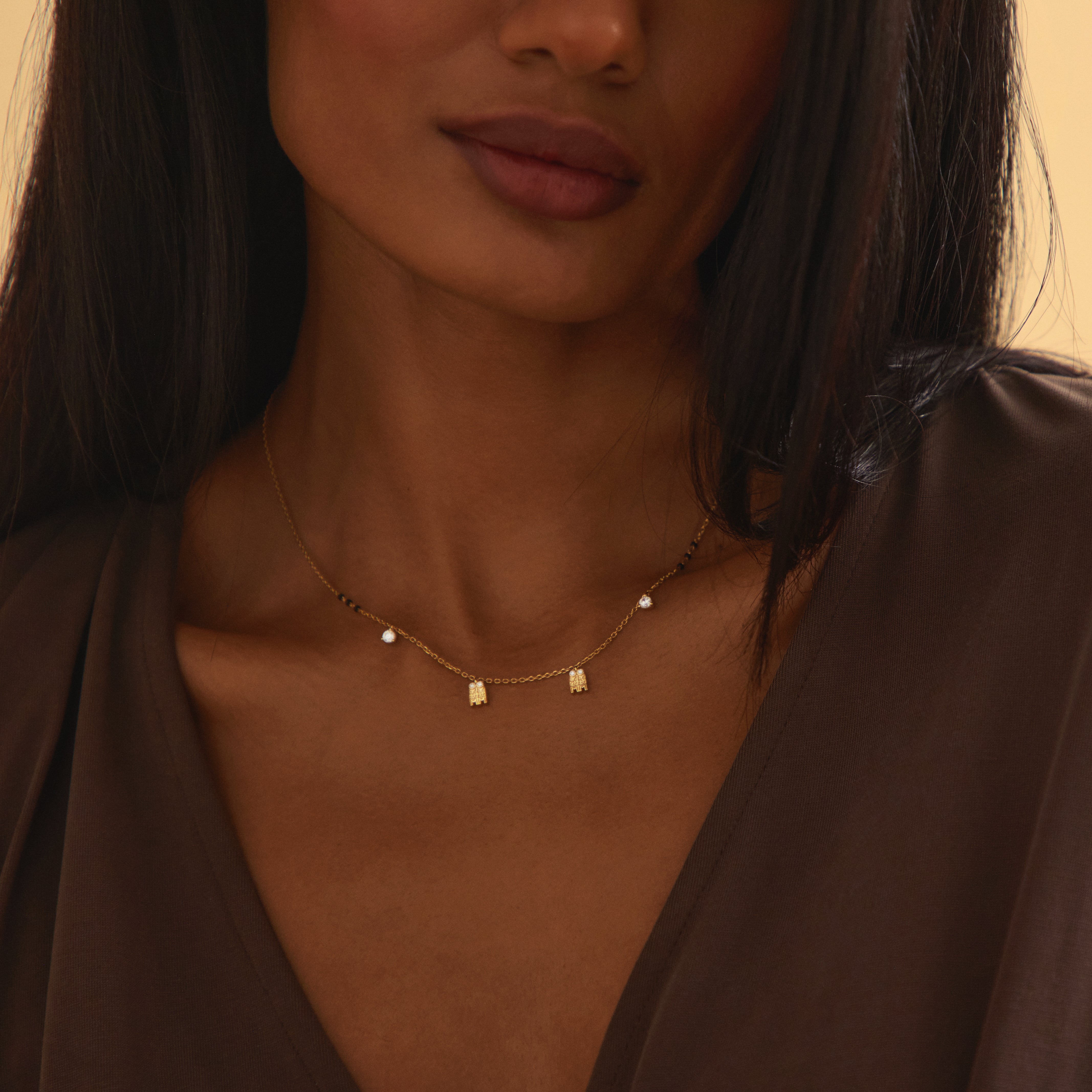 Close-up image of model wearing Modern Mangal’s Meera Mangalayam, a yellow gold Tamil mangalsutra with tulsi-inspired diamond pendants and dangle diamonds on a Harmony Chain, honoring South Indian bridal heritage.