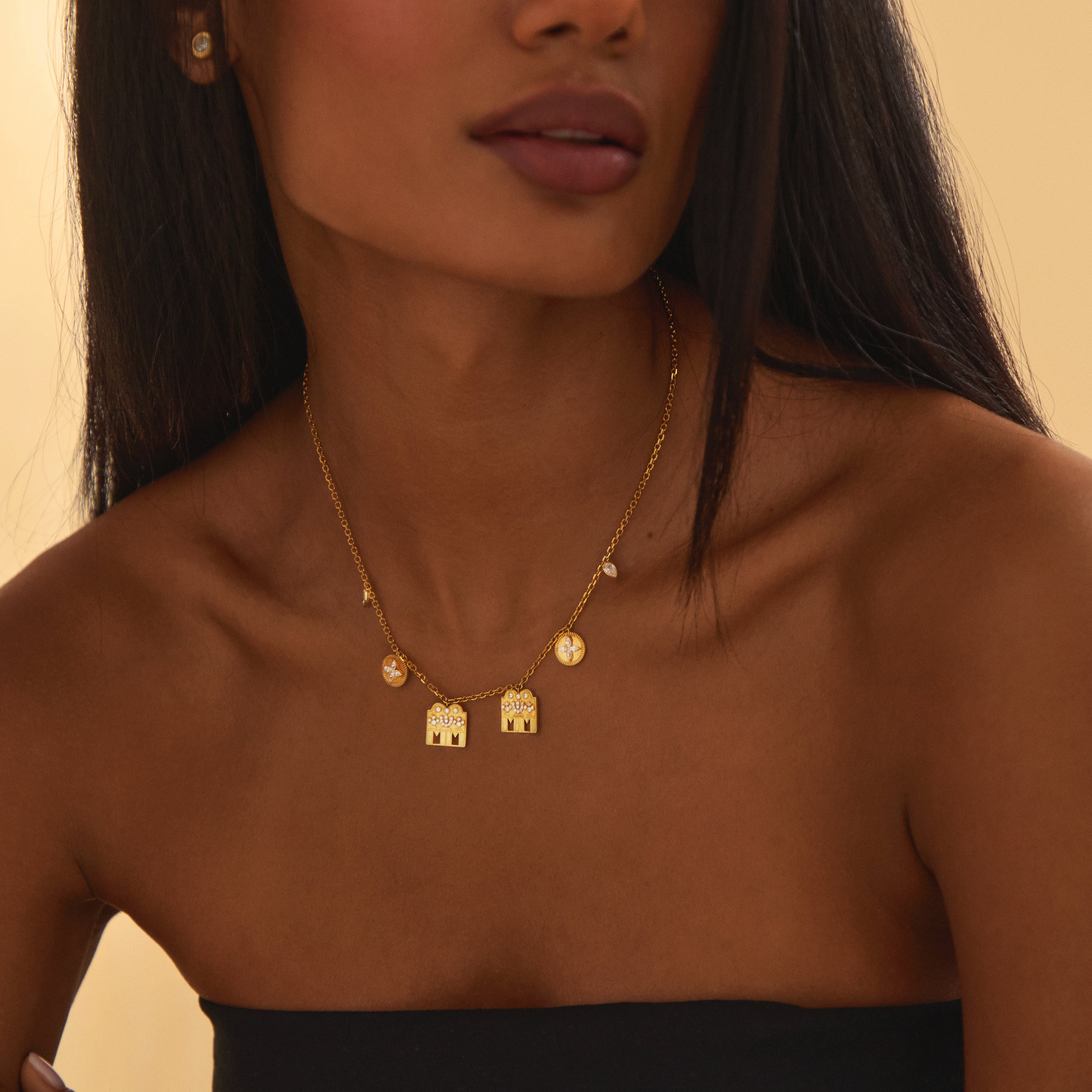 Close-up of the Modern Mangal Monica Mangalayam’s intricate charms on model: two diamond-studded Shivling pendants paired with marquise flower coins and pear bezel mango-leaf diamonds, symbolizing union, growth, and tradition in a modern mangal.