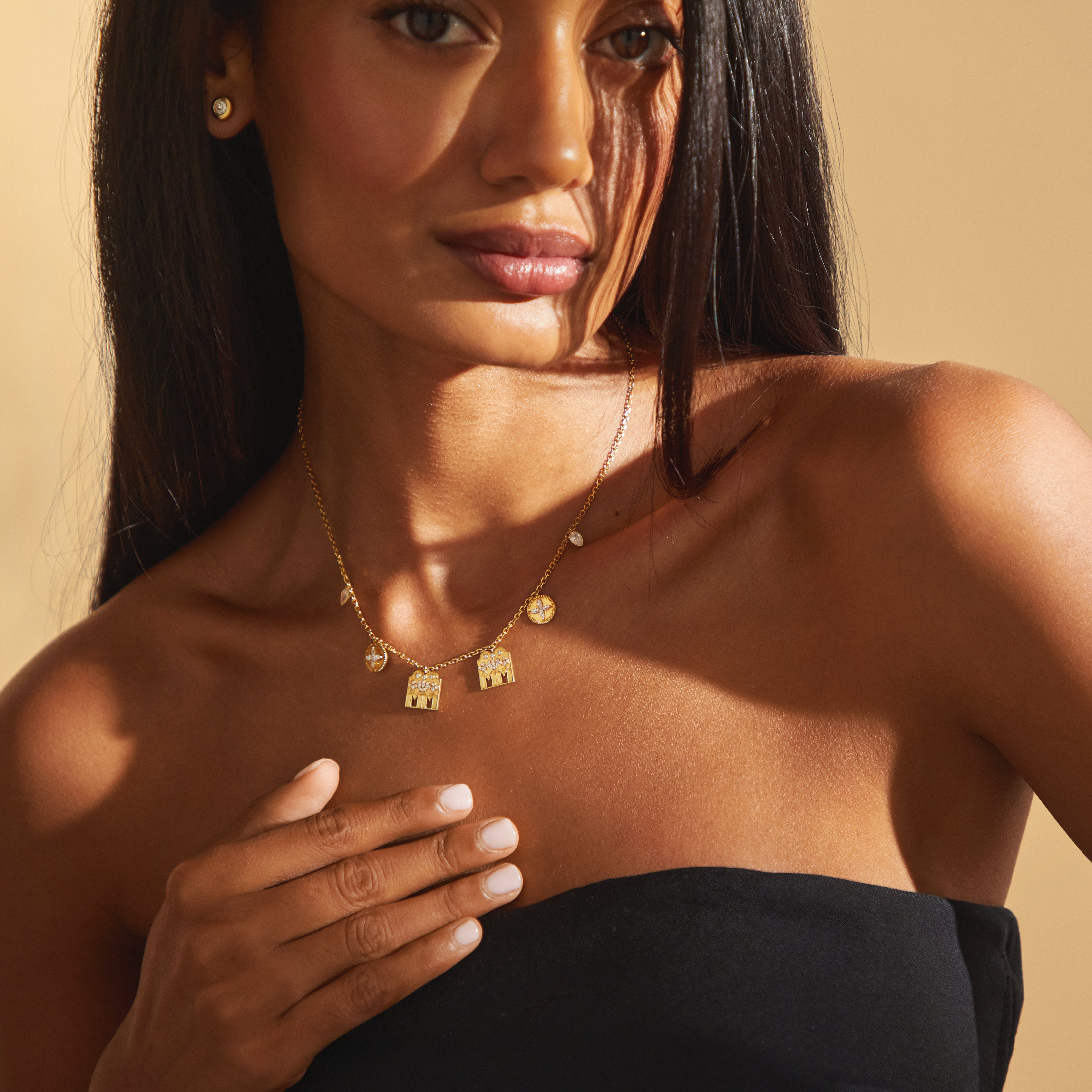 Model wearing the Modern Mangal Monica Mangalayam Tamil mangalsutra in 18K yellow gold, featuring twin diamond-encrusted Shivling pendants and symbolic floral and mango leaf charms on a modern chain, celebrating partnership and Tamil tradition.