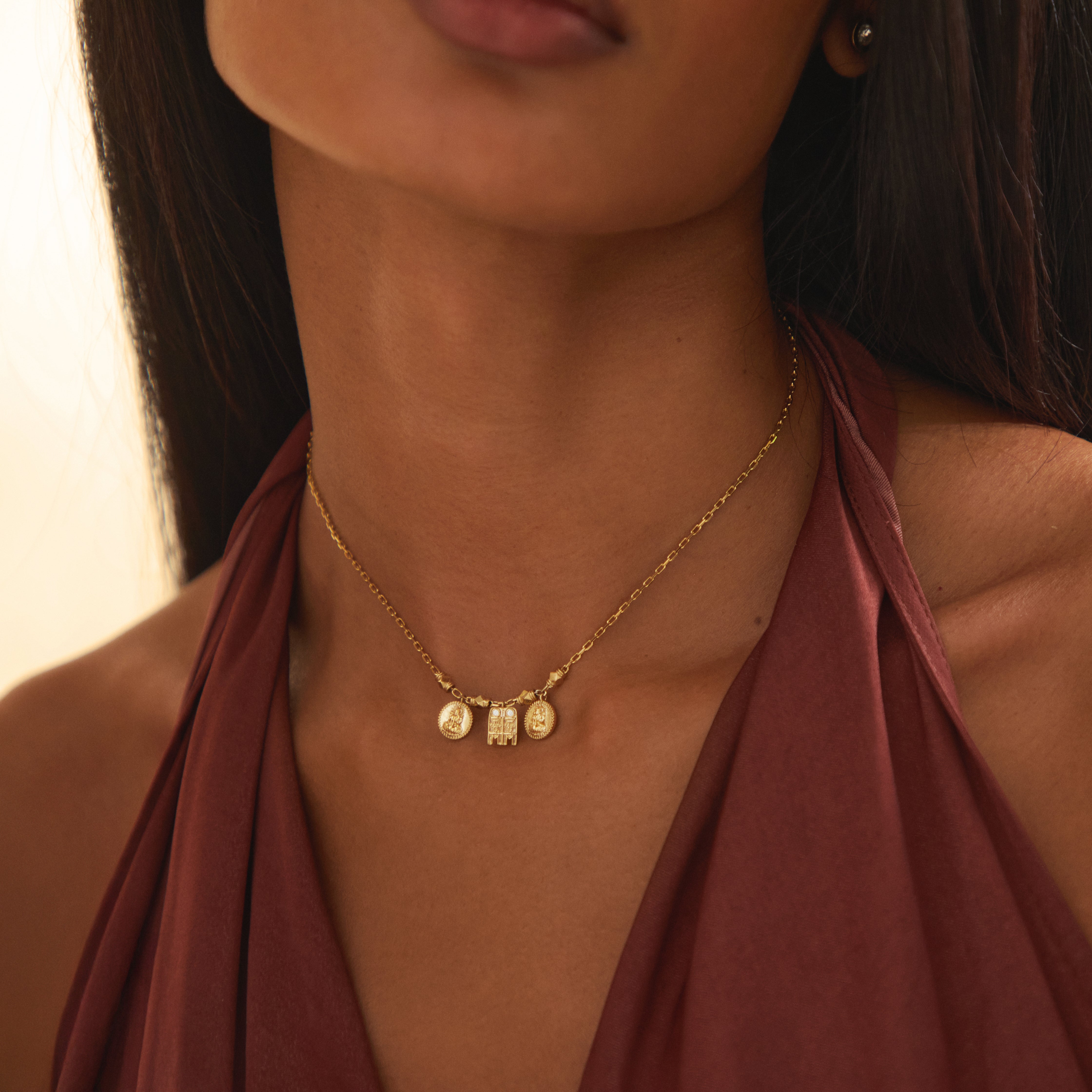 A medium close-up of a model wearing the Sriya Mangalayam in yellow gold by Modern Mangal, featuring a central mangalayam and two Lakshmi kasu coins, showcasing Tamil-inspired heritage and modern bridal elegance.