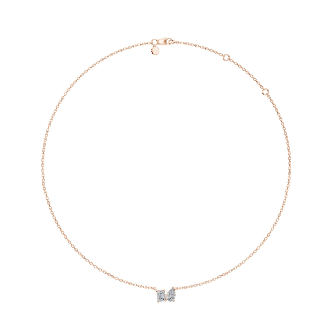 Full necklace view of the Modern Mangal Viya Necklace in rose gold, showing the warm-toned chain and asymmetrical emerald and pear-cut diamond pendant.