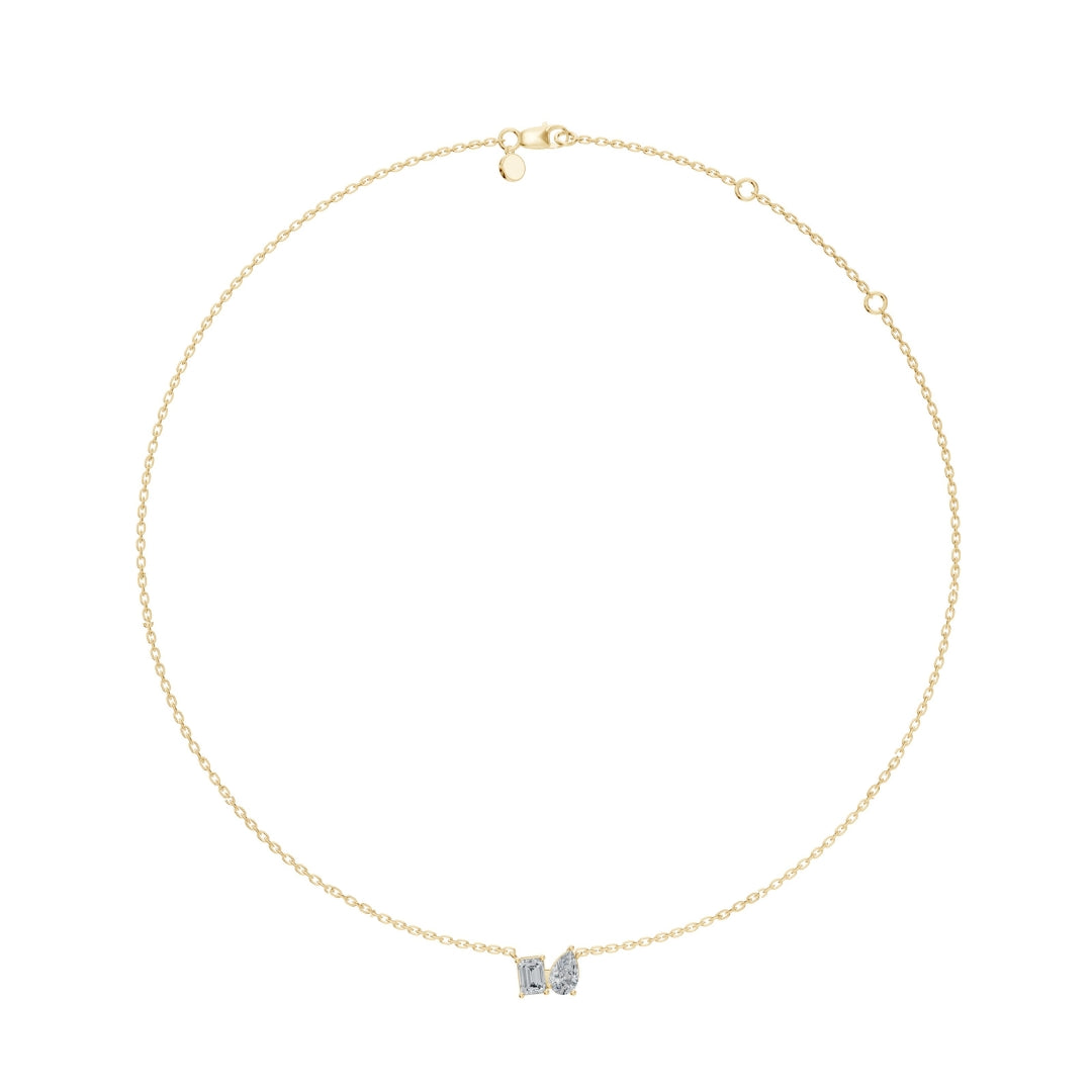 Full-length view of the Modern Mangal Viya Necklace in yellow gold, showing the fine gold chain and elegant Toi et Moi pendant with one emerald-cut and one pear-cut diamond.