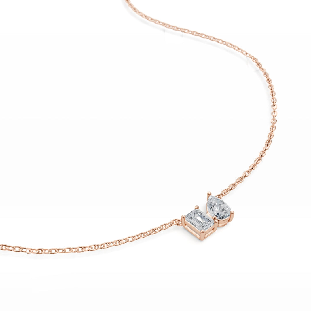 Detailed close-up of the Modern Mangal Viya Necklace in rose gold, highlighting the contrast between the angular emerald diamond and the curvy pear diamond.