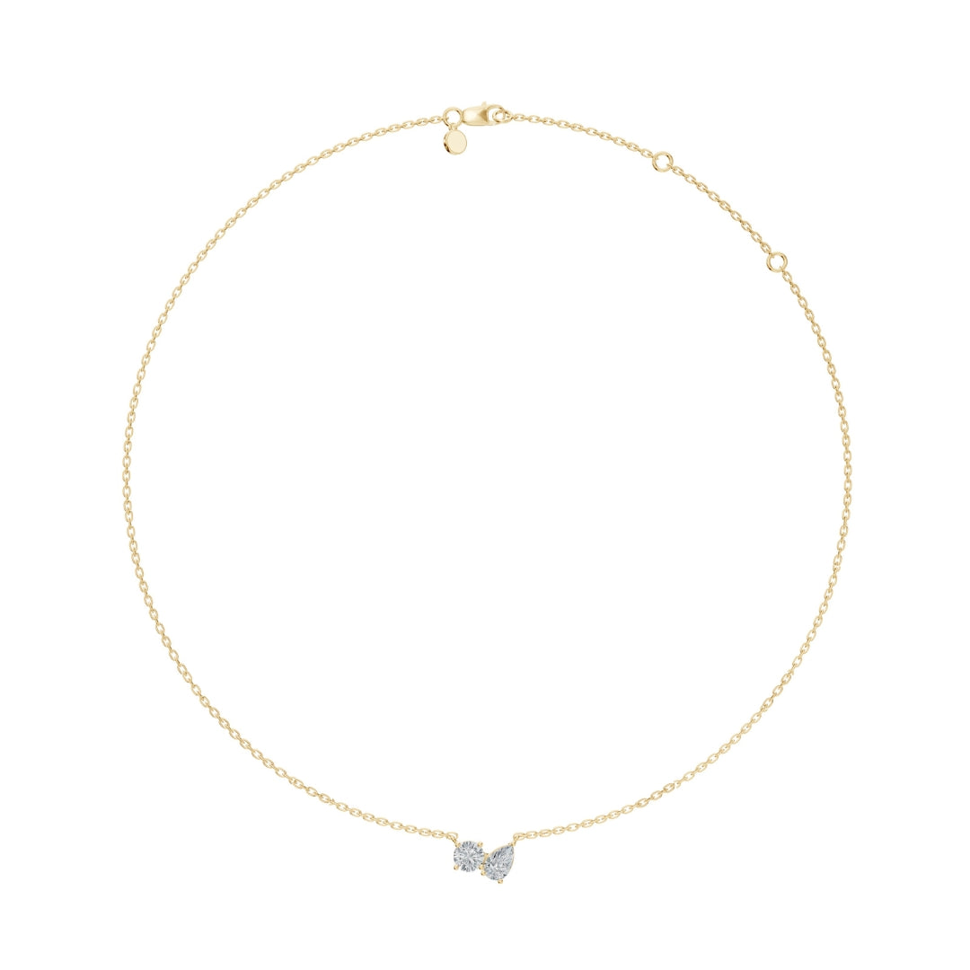 Flat-lay view of the yellow gold Modern Mangal nina Mangalsutra, featuring a beaded chain and a side-by-side pear and round diamond pendant in a Toi et Moi setting.