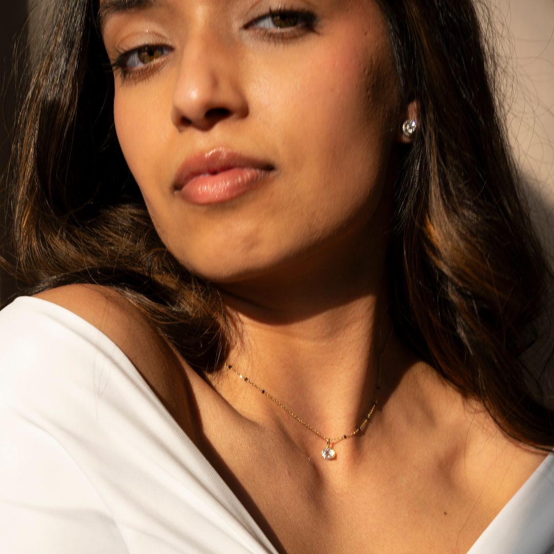 A woman wearing a Modern Mangal mangalsutra with a minimalist and elegant design. The mangalsutra features a delicate chain and a small, sparkling pendant, blending traditional South Asian heritage with contemporary style.