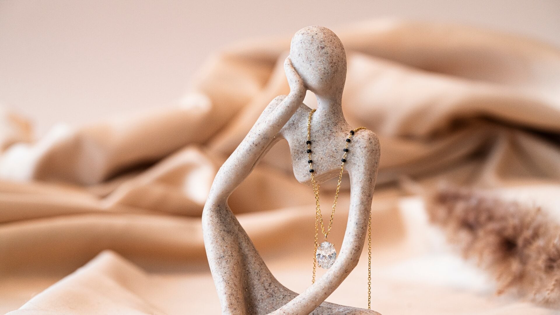 Artistic display of a Mangalsutra draped over a modern sculpture, showcasing elegant design and craftsmanship.