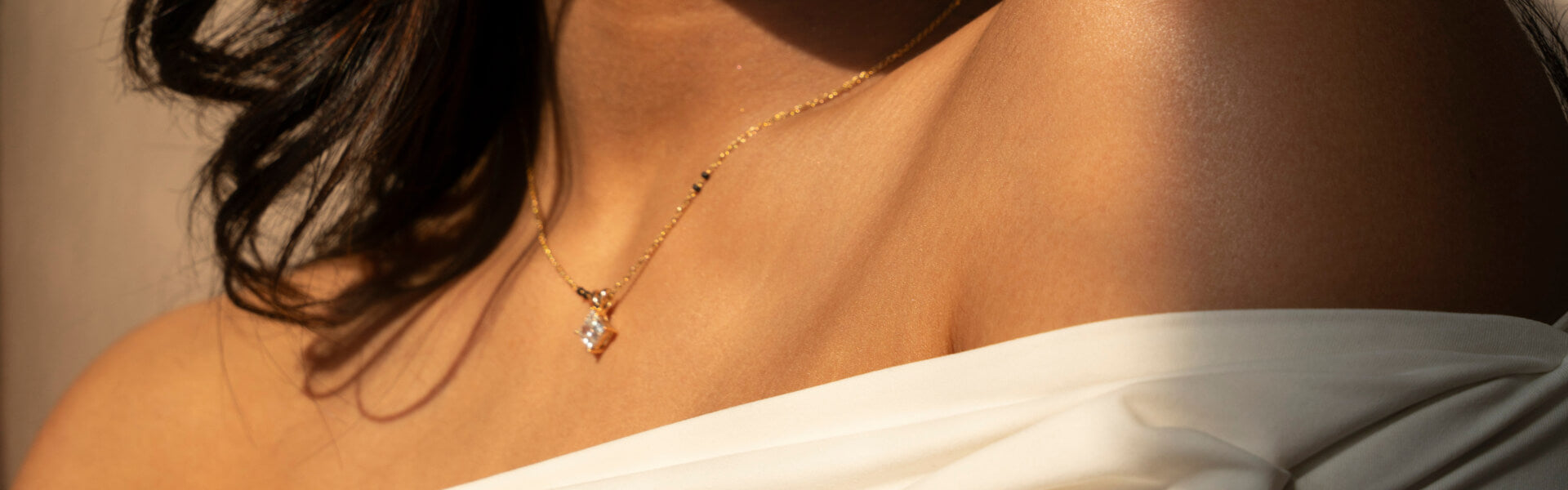 Elegant close-up of a Mangalsutra necklace with a gold and diamond pendant, draped beautifully across a woman's shoulder.