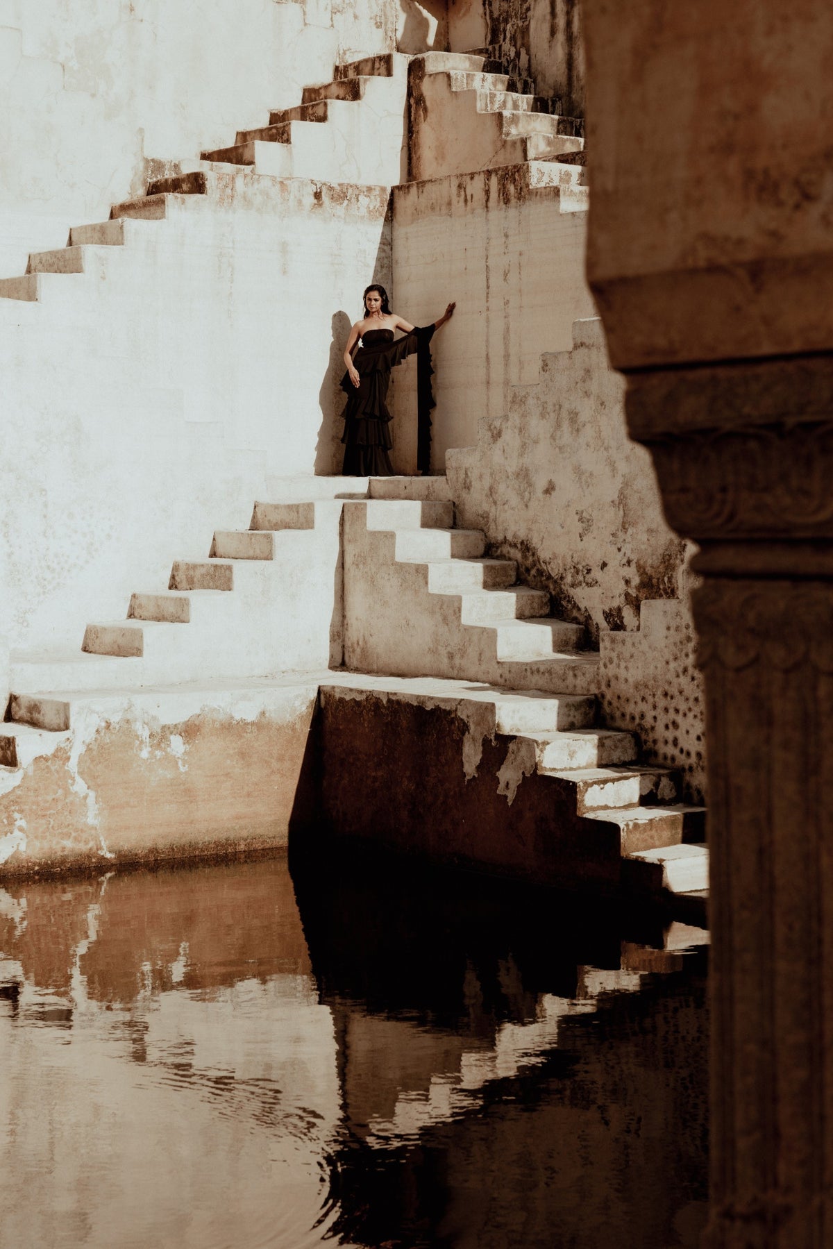 A woman standing on the steps of a historic stepwell in Rajasthan