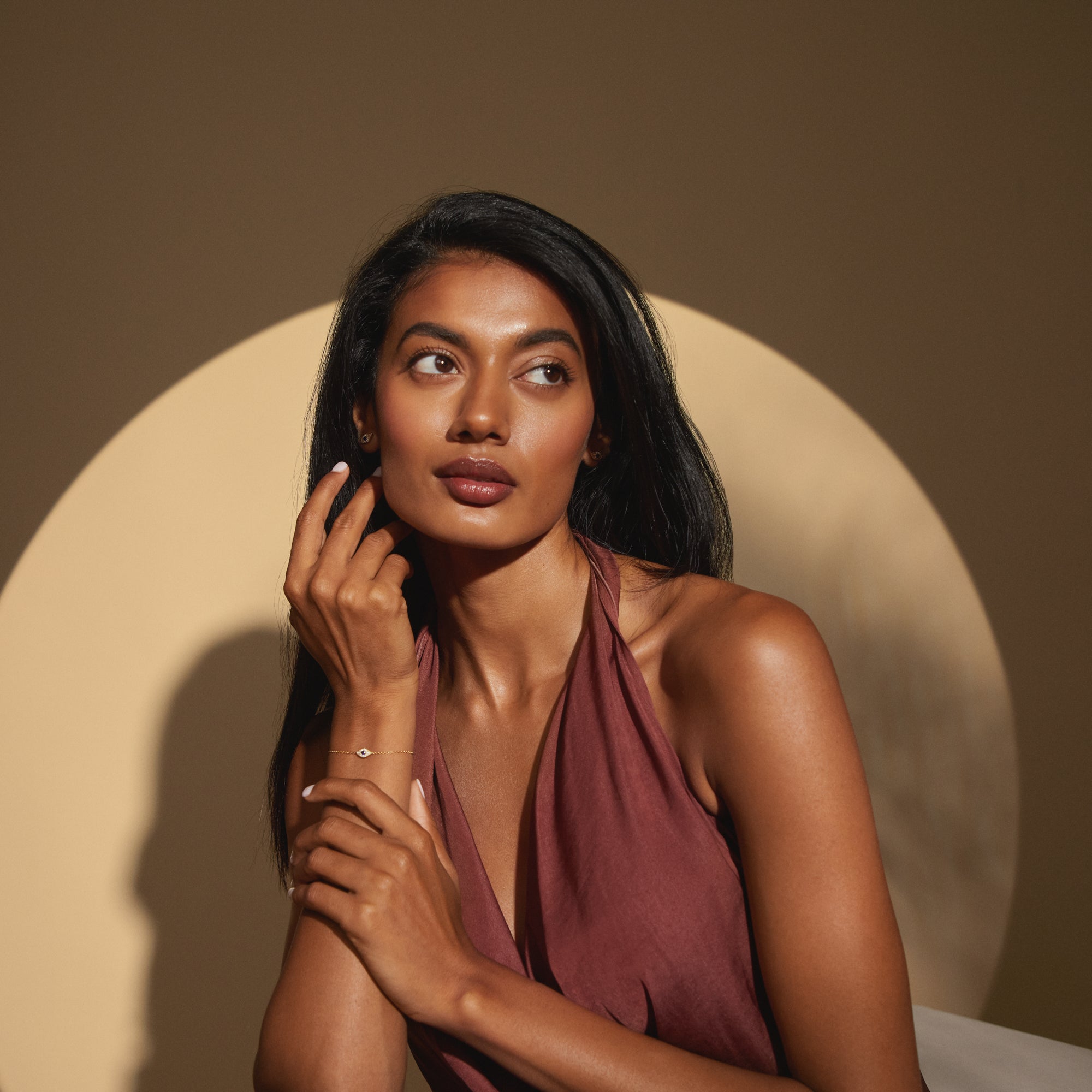 Lifestyle portrait of model wearing the Modern Mangal Aira Bracelet, highlighting its refined silhouette and luminous sapphire centerpiece on a gold chain.