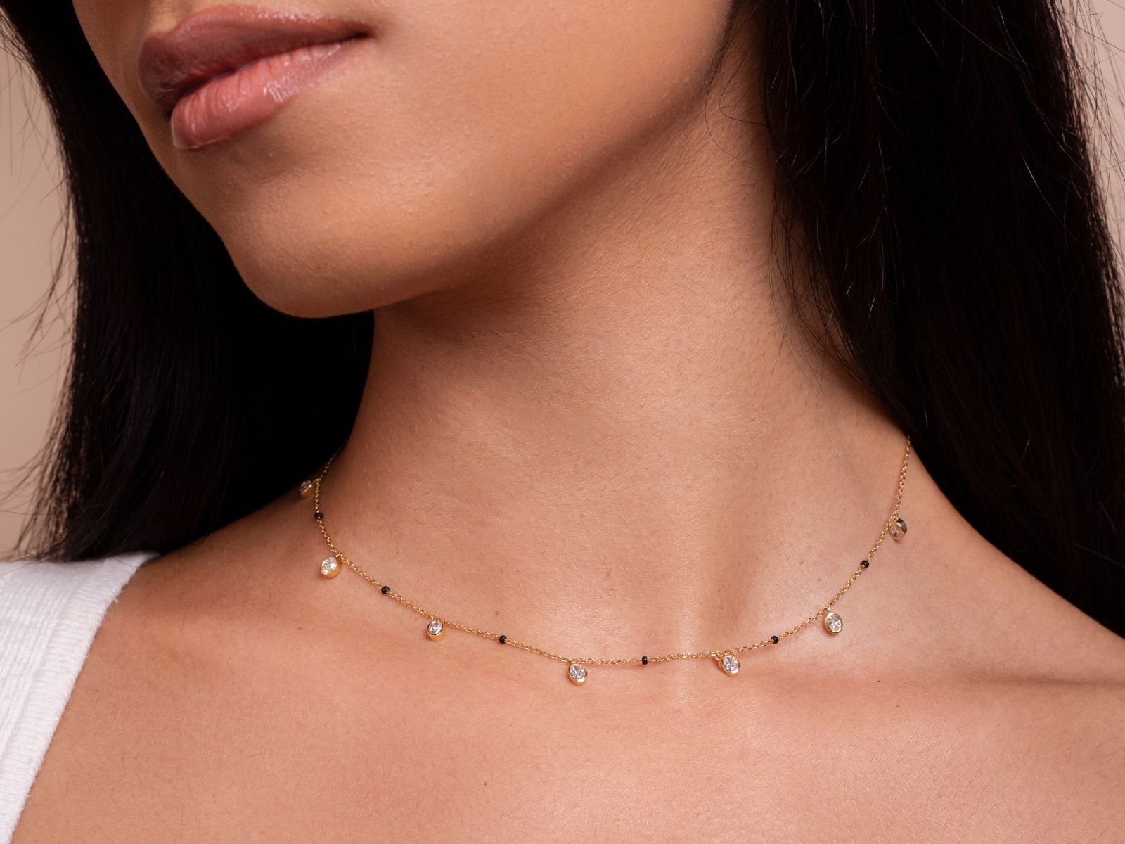 Close-up of the Ashna Necklace from the Modern Mangal x Ashna Gray Collection, featuring a delicate gold chain with black beads, blending traditional and modern aesthetics for a timeless look.