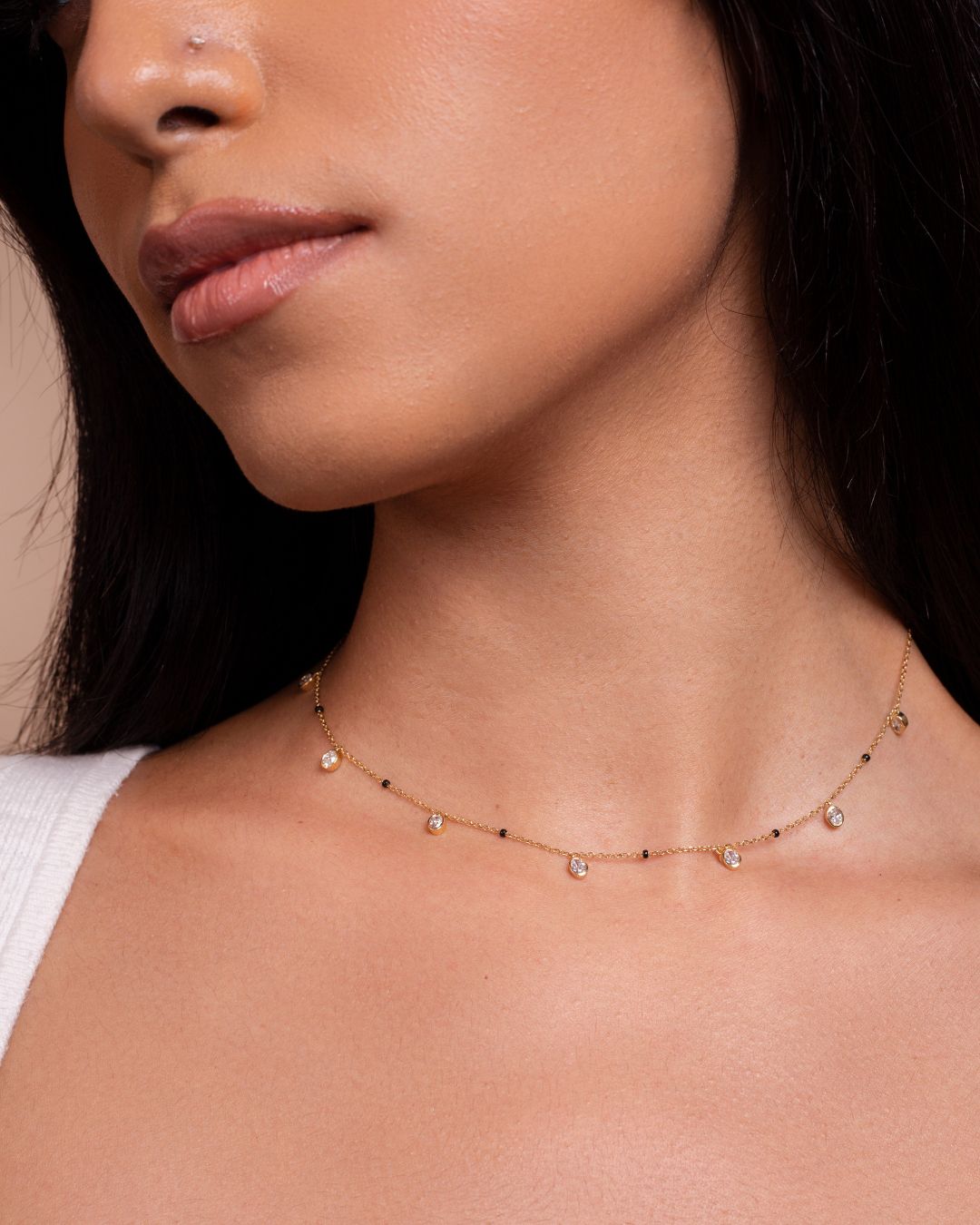 Close-up of the Ashna Necklace from the Modern Mangal x Ashna Gray Collection, featuring a delicate gold chain with black beads, blending traditional and modern aesthetics for a timeless look.