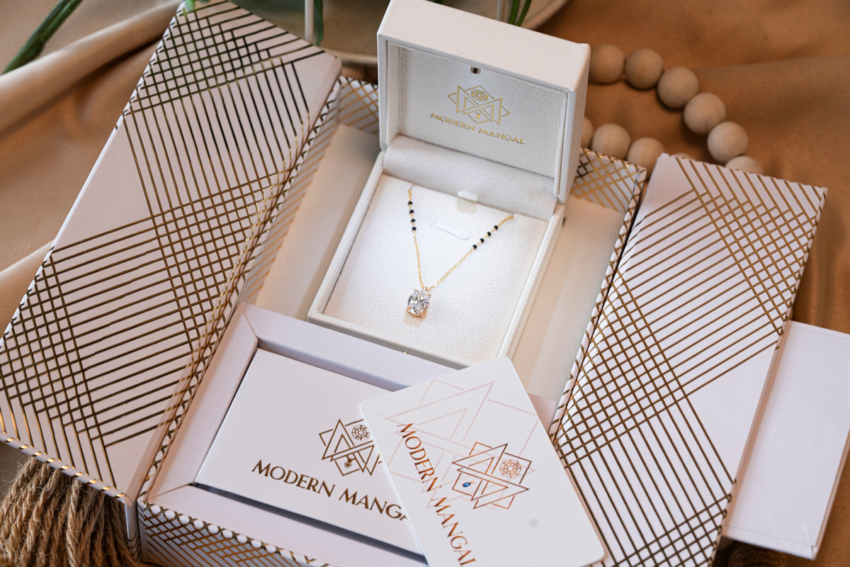 A Modern Mangal mangalsutra resting in its box with the care card