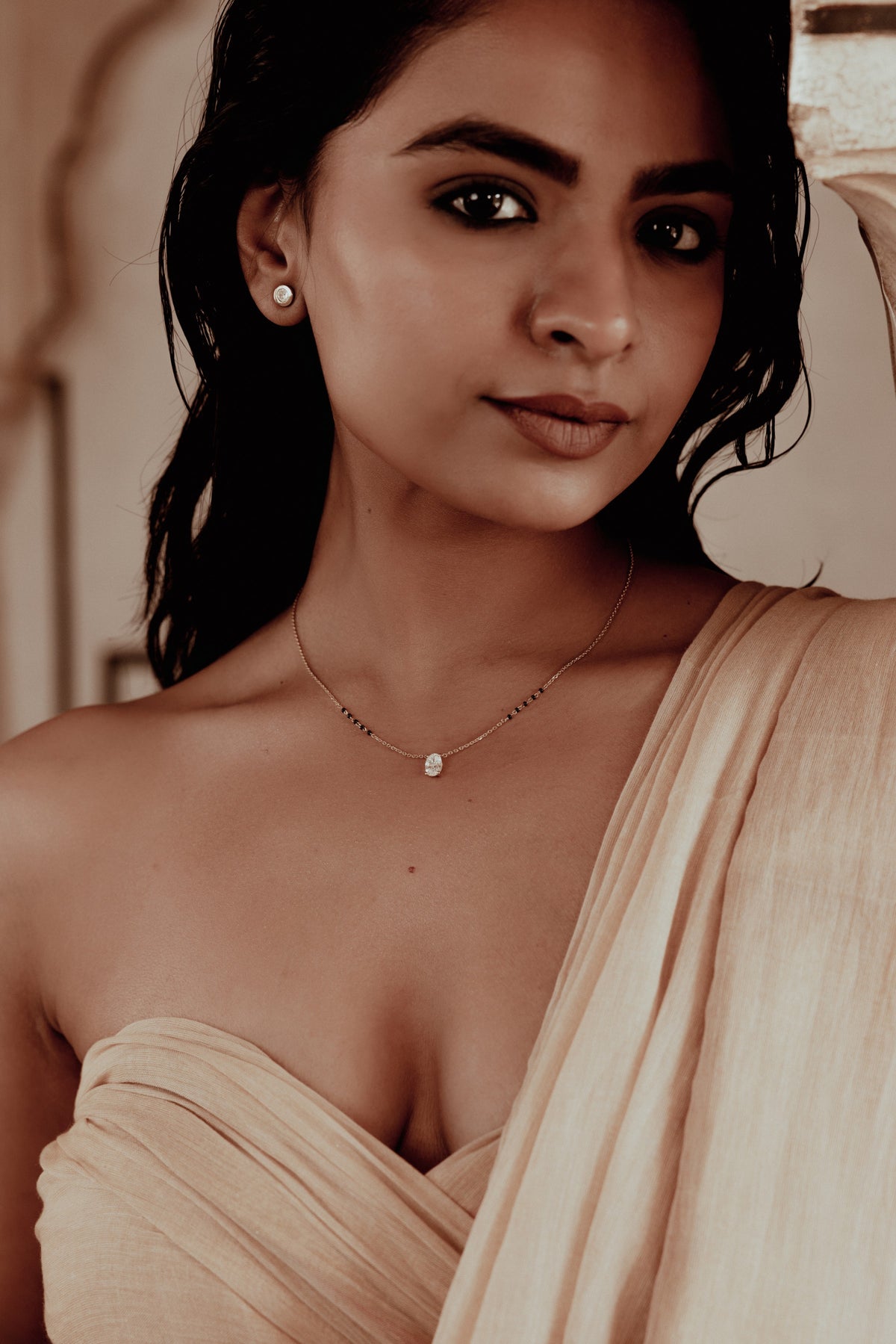A woman in a peach silk sari wearing a diamond mangalsutra, Jaipur