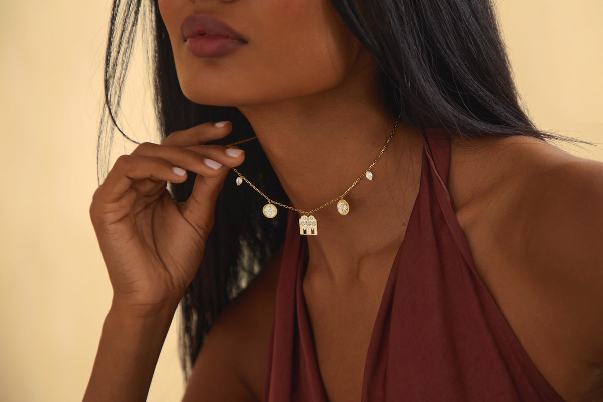 A gold thaali pendant at the neckline, warm studio light