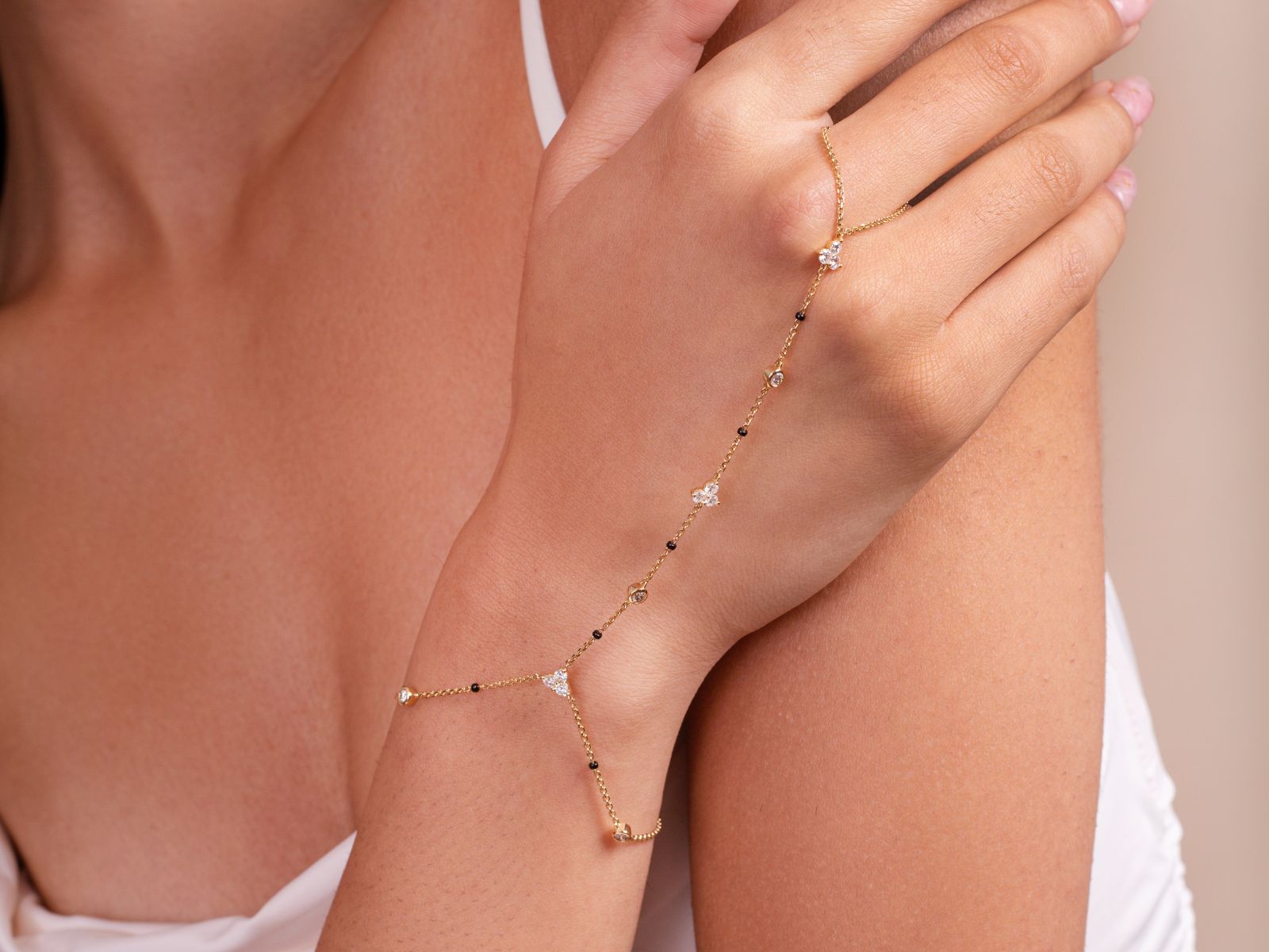 Model’s hand adorned with the Harmony Hand Chain from the Modern Mangal x Ashna Gray Collection, featuring a delicate gold chain with black beads and diamond accents, blending traditional elegance with modern style.