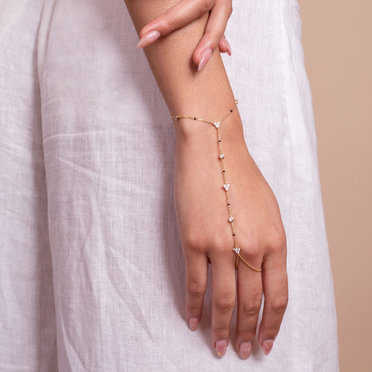 Model’s hand wearing the Harmony Hand Chain from the Modern Mangal x Ashna Gray Collection, a unique piece with diamond and black bead accents for an elegant touch.