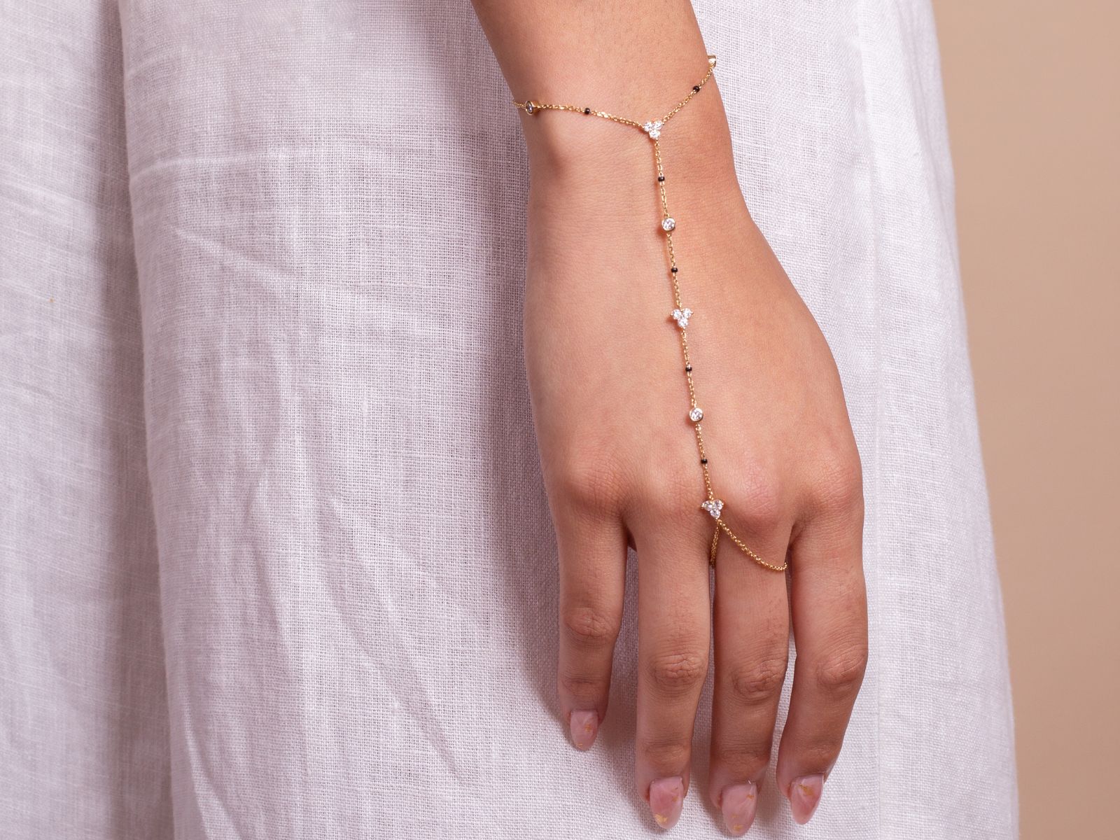 Model wearing the Harmony Hand Chain from the Modern Mangal x Ashna Gray Collection, a unique piece featuring a fine gold chain that wraps gracefully around the hand, combining elegance with tradition.