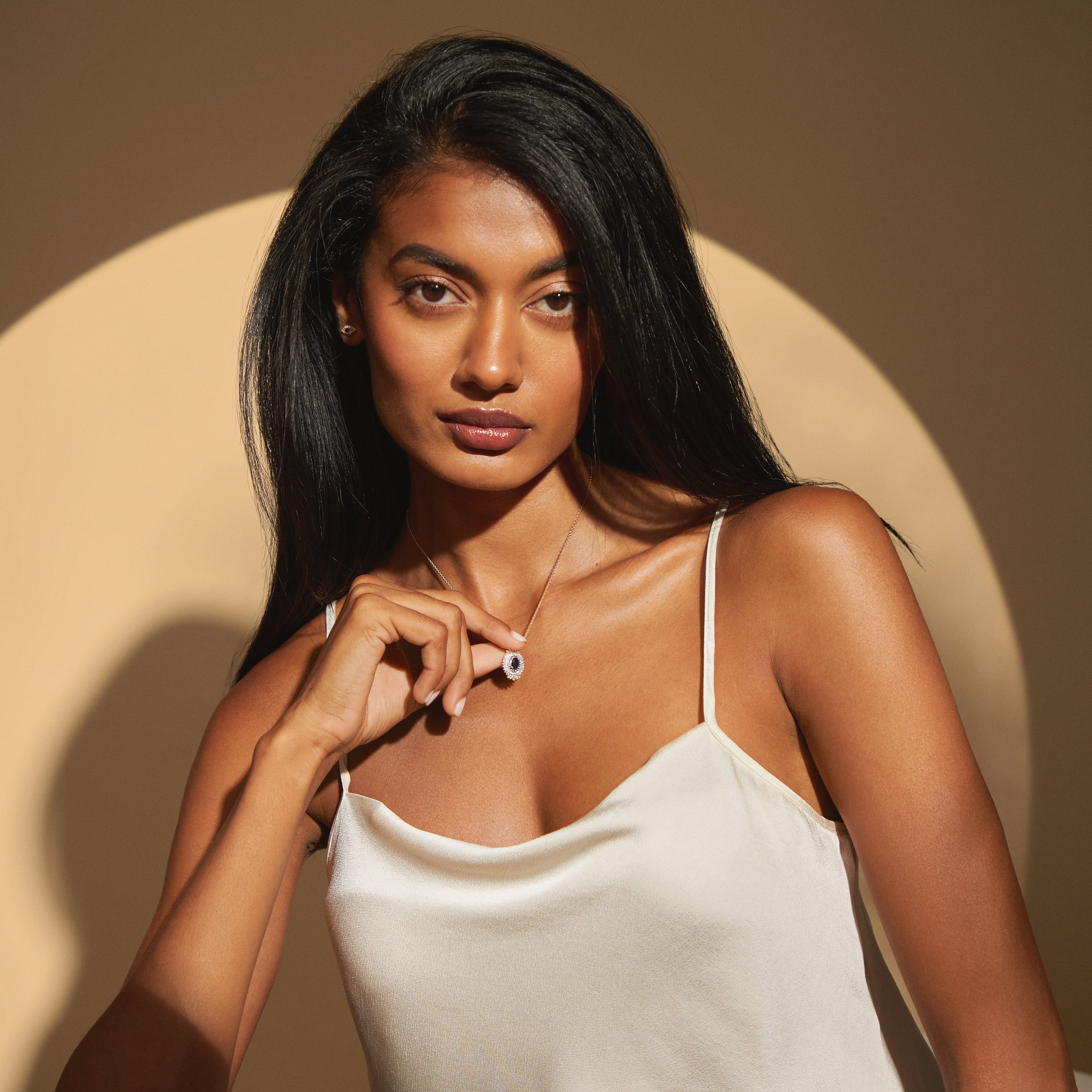 Front view of the Leila Necklace in yellow gold, modeled in a softly lit setting. The elegant pendant features stacked black onyx, blue sapphires, and diamonds for a powerful, timeless look.