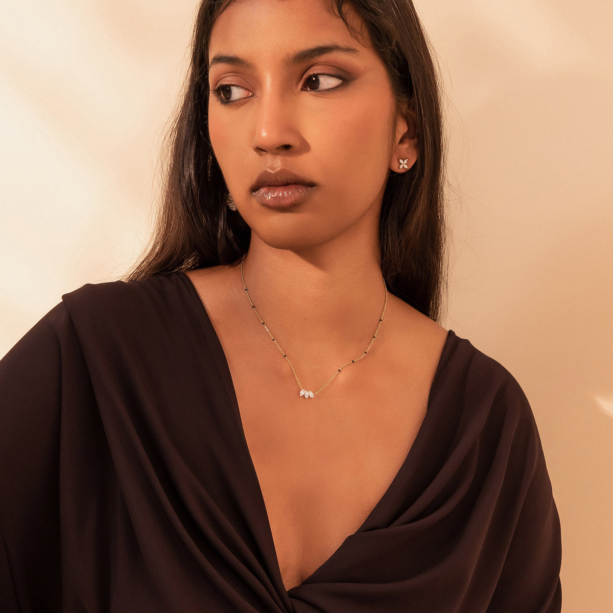 Model wearing the Vanisha Mangalsutra in 18K gold with a leaf pendant of marquise diamonds and black beads