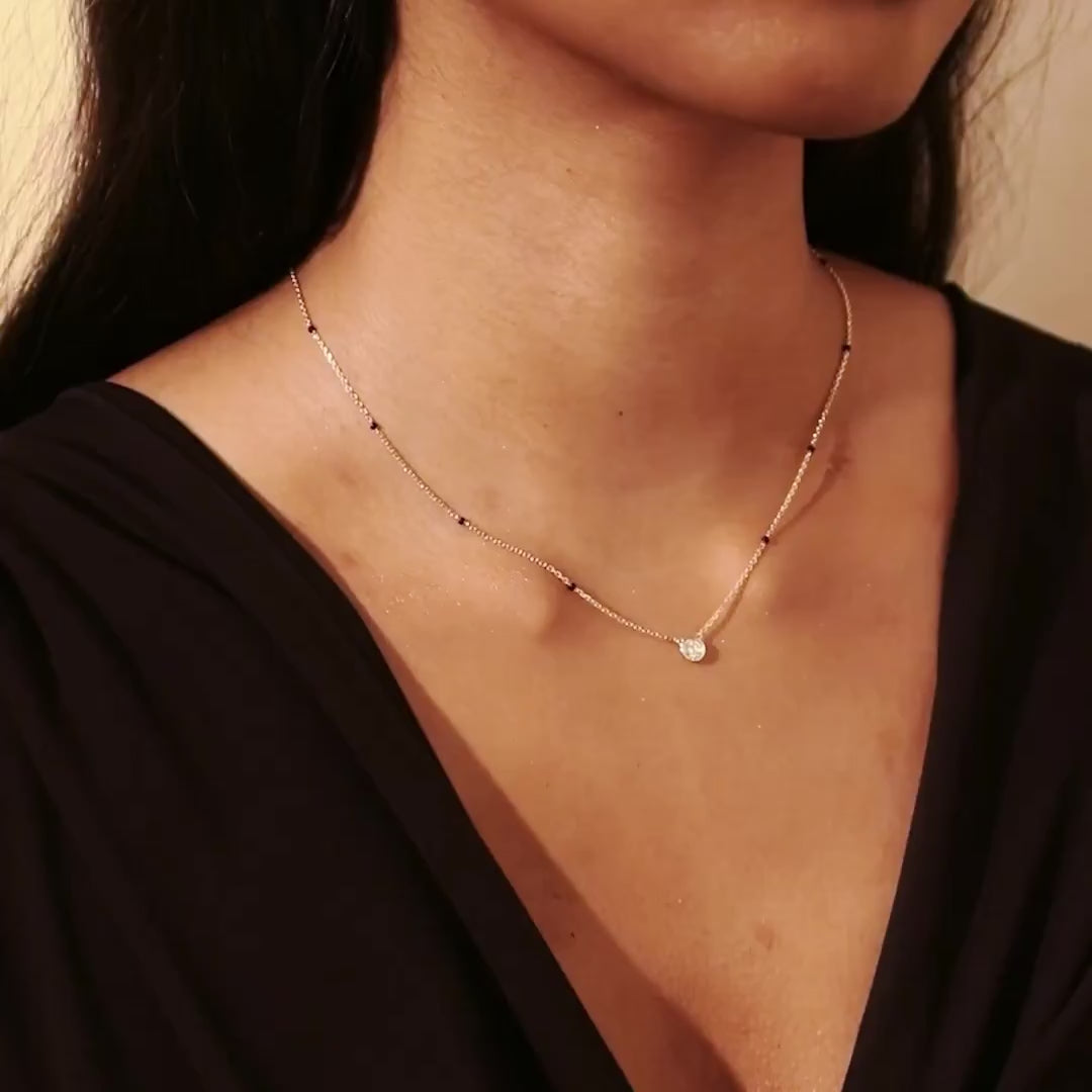 Video of the Model wearing Modern Mangal Minnie Mangalsutra in yellow gold worn by a model, with the round bezel diamond gently reflecting light with every movement.
